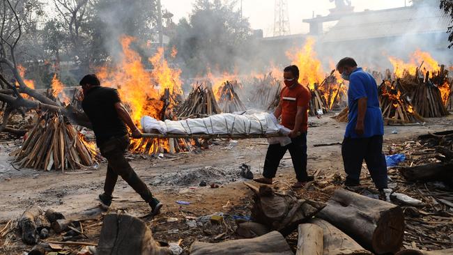 Workers carry the body of a Covid victim through funeral pyres in Delhi. Picture: Getty Images