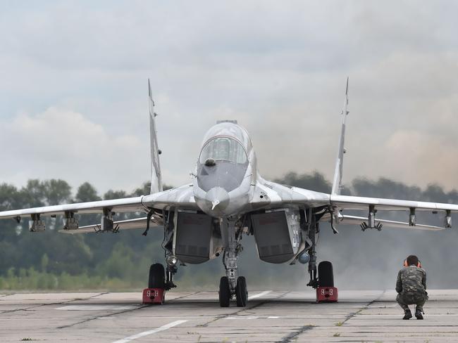 A technician looks at a Ukrainian MIG-29 fighter prior to taking off during exercises at the air force military base in the small town of Vasylkiv last month. Picture: Sergei Supinksy