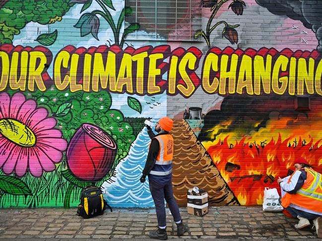 Artists paint a mural on a wall next to the Clydeside Expressway near Scottish Events Centre which will be hosting the COP26 UN Climate Summit. Picture: Getty Images