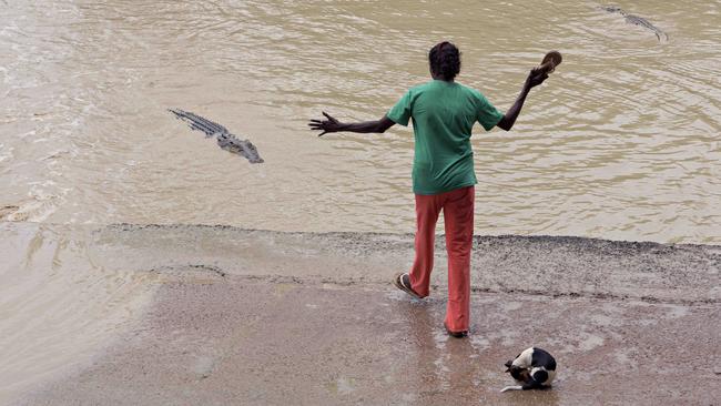 A woman tries to scare away a saltwater crocodile using her thong at Cahills Crossing. PICTURE: Michael Franchi