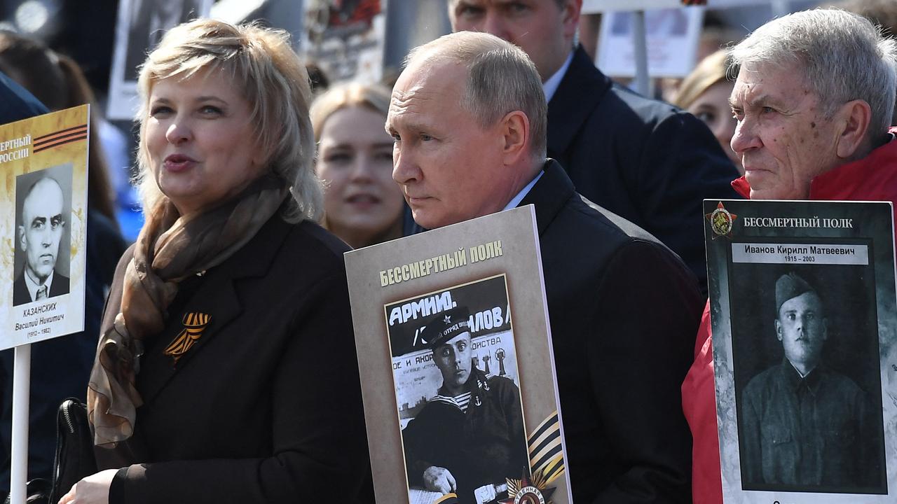 Mr Putin and other participants carry portraits of their relatives – WWII soldiers – as they take part in the Immortal Regiment march. Picture: Natalia Kolesnikova/AFP