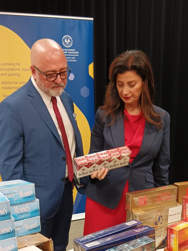 Former Consumer Affairs Commissioner Martyn Campbell and Ms Michaels inspecting some of the illegal tobacco items seized during a raid in the northeastern suburbs. Picture: Elizabeth Henson