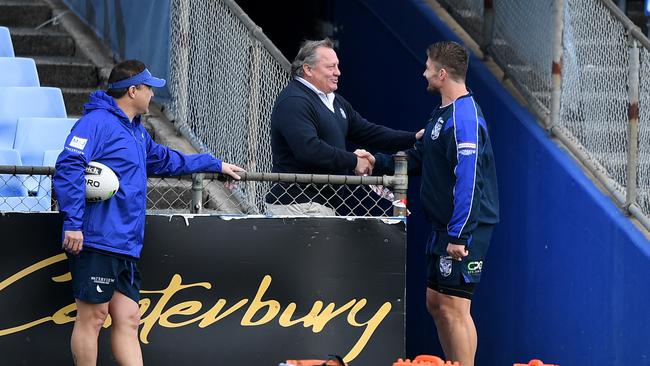 Bulldogs great Terry Lamb breaks COVID-19 protocols by shaking hands with Kieran Foran. Picture: AAP