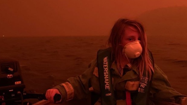 A mother took this photo of her son last summer Finn Burns when they sought shelter from the fire on a boat on Mallacoota Lake. It doesn’t look like it, but it’s daytime.