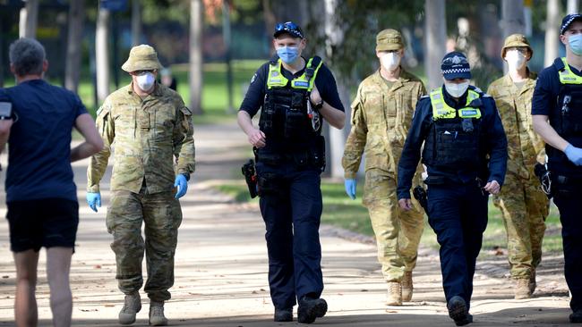 Police and ADF personnel patrol the Tan at South Yarra. Picture: Andrew Henshaw