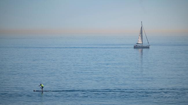 A man paddle boards off San Sebastian beach in Barcelona, where temperatures hit 30°C amid an unusual mid-January heatwave. Picture: Josep Lago/AFP