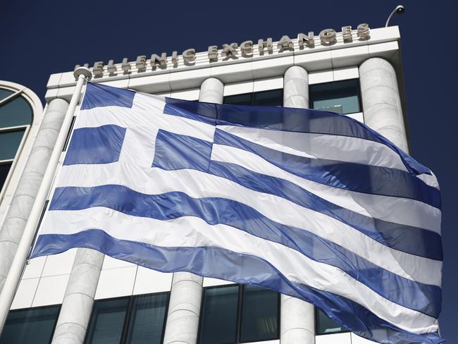 FILE - In this Feb. 3, 2015, file photo, a Greek flag flies outside the Athens Stock Exchange. In 2012, financial markets were rattled by the possibility Greece would elect a left-wing government, default on their debts and drop the euro currency. In 2015, the left-wing party, Syriza, holds power in Athens. Greece actually did miss a loan payment to the International Monetary Fund late Tuesday, June 30, 2015. And the nation's future in the eurozone hinges precariously on a referendum Sunday, July 5, 2015. (AP Photo/Petros Giannakouris, File)