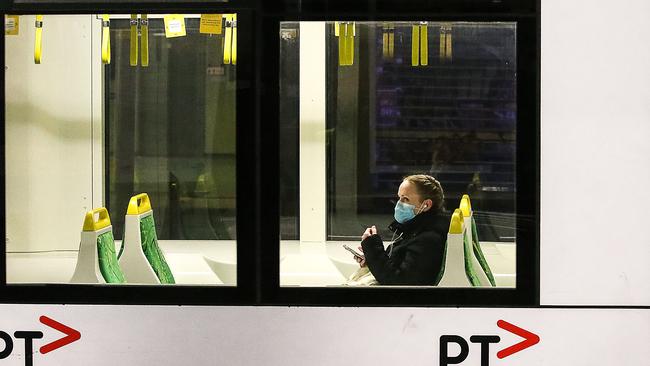 A woman wears a mask on a tram in Swanston Street. Picture: Ian Currie