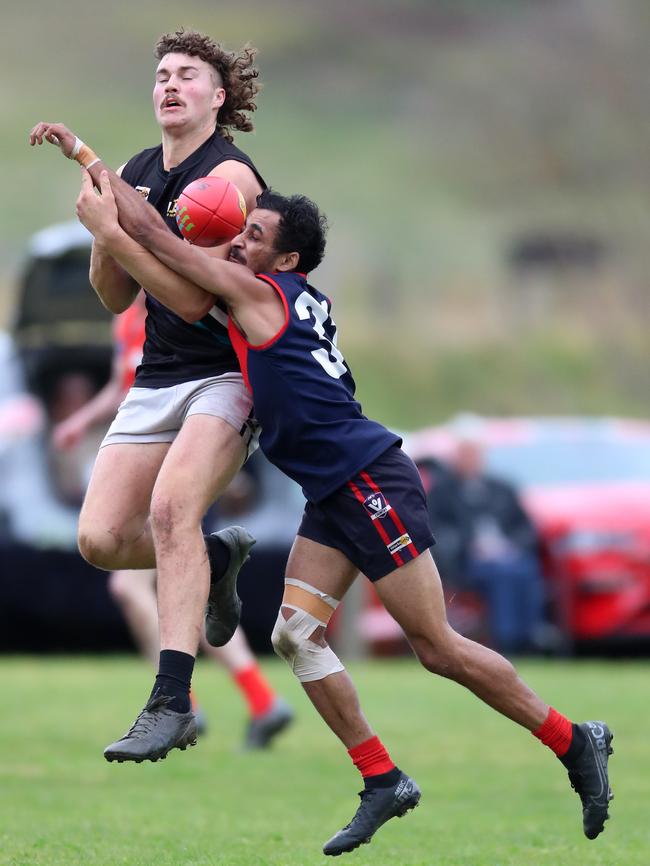 Omeo-Benambra’s Jai Hayward is pressured by Swifts Creek’s Arthur Wright.