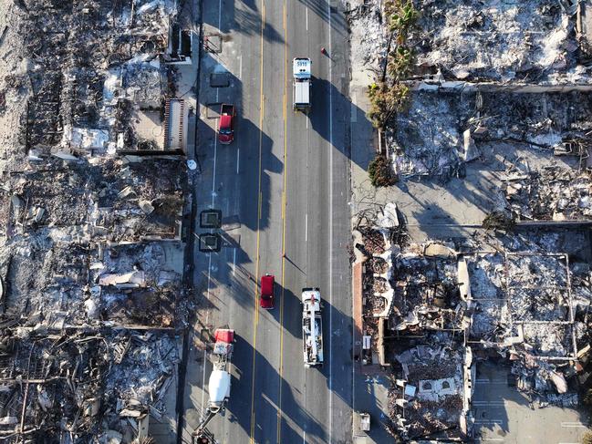 MALIBU, CALIFORNIA - JANUARY 16: An aerial view of a fire truck (TOP) driving past beachside homes destroyed in the Palisades Fire as wildfires cause damage and loss through the LA region on January 16, 2025 in Malibu, California. Multiple wildfires which were fueled by intense Santa Ana Winds have burned across Los Angeles County leaving at least 27 dead with over 180,000 people having been under evacuation orders. Over 12,000 structures have been burned in the Palisades and Eaton Fires.   Mario Tama/Getty Images/AFP (Photo by MARIO TAMA / GETTY IMAGES NORTH AMERICA / Getty Images via AFP)