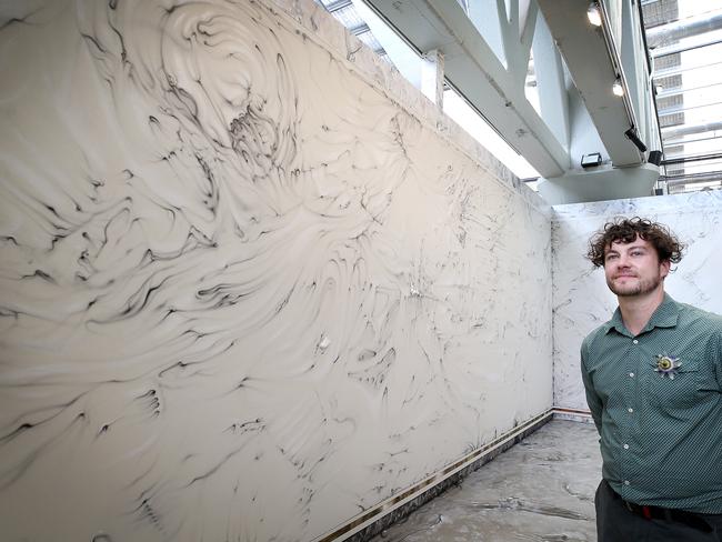 Artist Josh Foley with his acrylic and resin sculptural elements on masonry wall titled Approximations at Inveresk, Launceston. as part of Mofo. PICTURE CHRIS KIDD