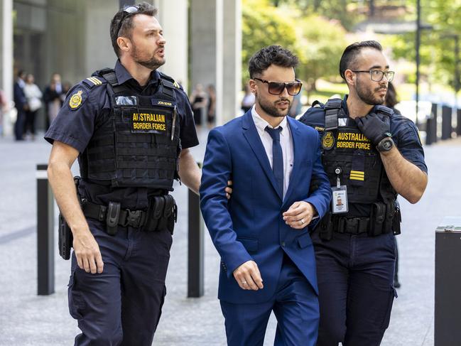 Giovanni Genuario is taken away by Australian Boarder Force officers as he leaves Brisbane Supreme court.