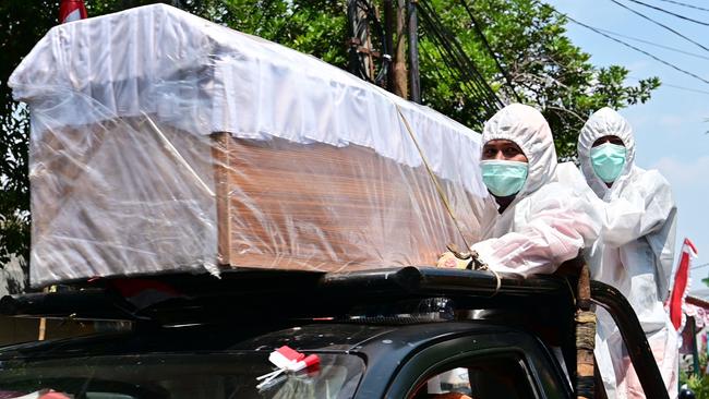 Workers wearing protective suits travel with a mock coffin as part of an awareness drive against COVID-19 in Jakarta earlier this month. Picture: AFP