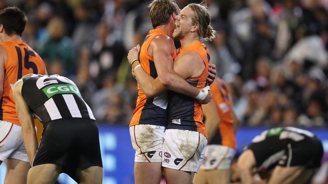 Giants Harrison Himmelberg and Jeremy Finlayson embrace on the final siren as Collingwood players slump in despair. Picture: Michael Klein