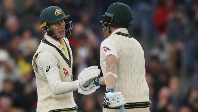 Australia's Steve Smith, right, congratulates teammate Marnus Labuschagne for scoring fifty runs during day one of the fourth Ashes Test cricket match between England and Australia at Old Trafford in Manchester, England, Wednesday, Sept. 4, 2019. (AP Photo/Rui Vieira)