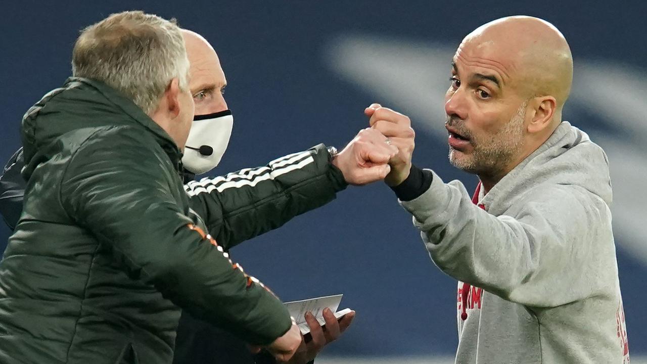 Ole Gunnar Solskjaer and Pep Guardiola bump fists. (Photo by Dave Thompson / POOL / AFP)