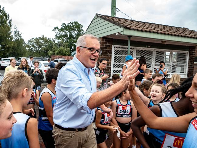 Scott Morrison high-fives some kids at Sylvania Waters Athletics Track in Sydney. Picture: NCA NewsWire/Flavio Brancaleone