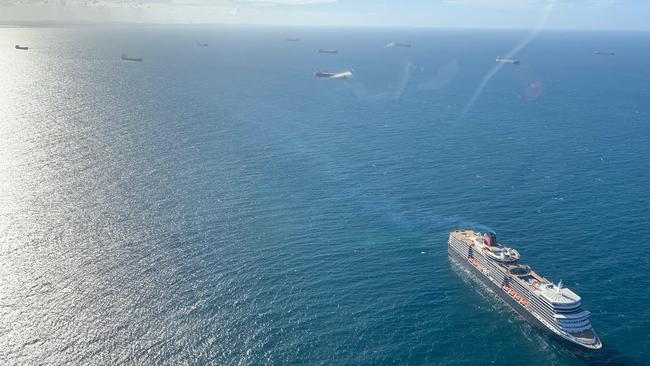 Cargo ships anchored off the Port of Gladstone yesterday, and the MS Queen Elizabeth (Cunard Line) on an 11-day round trip from NZ that started on March 11. Picture: Supplied