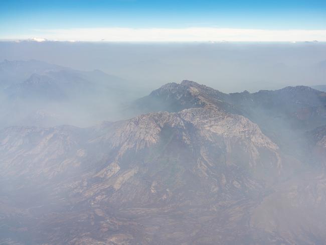 2019 Tasmanian bush fires. Crags of Andromeda and West Portal shrouded in smoke, Western Arthur Range, Riveaux Road Fire - at Southwest National Park. . Picture - LUKE TSCHARKE / PAR AVION
