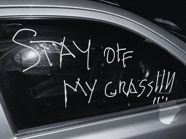 A northern Gold Coast resident parked her newly purchased car with two wheels on the grass to save room on her busy street when she was left with a confronting message scrawled on her window.