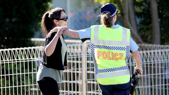 Police comfort a woman at the scene. Picture: Peter Lorimer