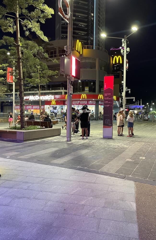 Two men get searched by police on Cavill Ave. Picture: Georgina Noack