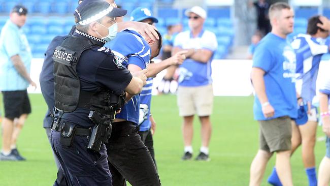 A man is removed from the field by police officers. Picture: Richard Gosling