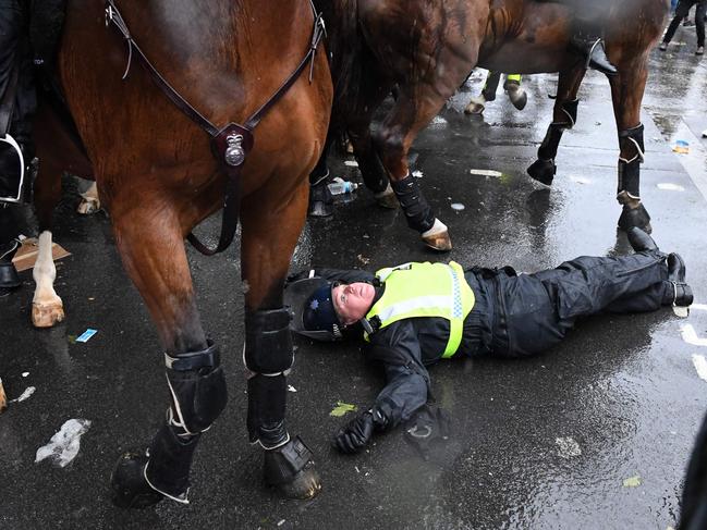 A mounted police officer lays on the road after being unseated from their horse, during a demonstration on Whitehall, near the entrance to Downing Street in central London on June 6, 2020, to show solidarity with the Black Lives Matter movement in the wake of the killing of George Floyd, an unarmed black man who died after a police officer knelt on his neck in Minneapolis. - The United States braced Friday for massive weekend protests against racism and police brutality, as outrage soared over the latest law enforcement abuses against demonstrators that were caught on camera. With protests over last week's police killing of George Floyd, an unarmed black man, surging into a second weekend, President Donald Trump sparked fresh controversy by saying it was a "great day" for Floyd. (Photo by DANIEL LEAL-OLIVAS / AFP)