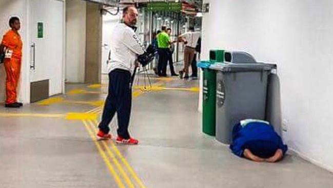 British judoka Ashley McKenzie has his head in his hands behind a garbage bin.