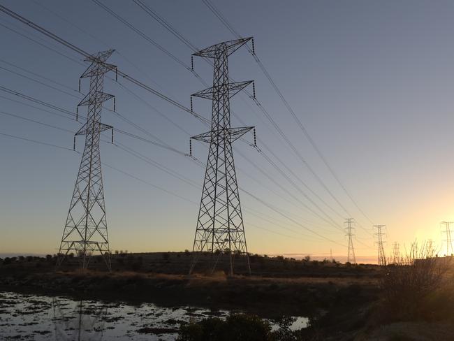 Power lines hang from transmission towers on Torrens Island, South Australia, on Monday, April 2, 2018. A plan byÃÂ Tesla Inc.ÃÂ to build the world's largest virtual power plant may be in jeopardy after the South Australian political party that championed the deal was ousted from government, setting up a potential retreat from ambitious renewableÃÂ energyÃÂ targets. Photographer: Carla Gottgens/Bloomberg via Getty Images