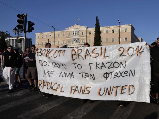 Youths hold a banner reading "Brazil 2014 - they water the grass with the blood of the poor" as they demonstrate in solidarity with the poor of Brazil and call for a boycott of the FIFA World Cup.