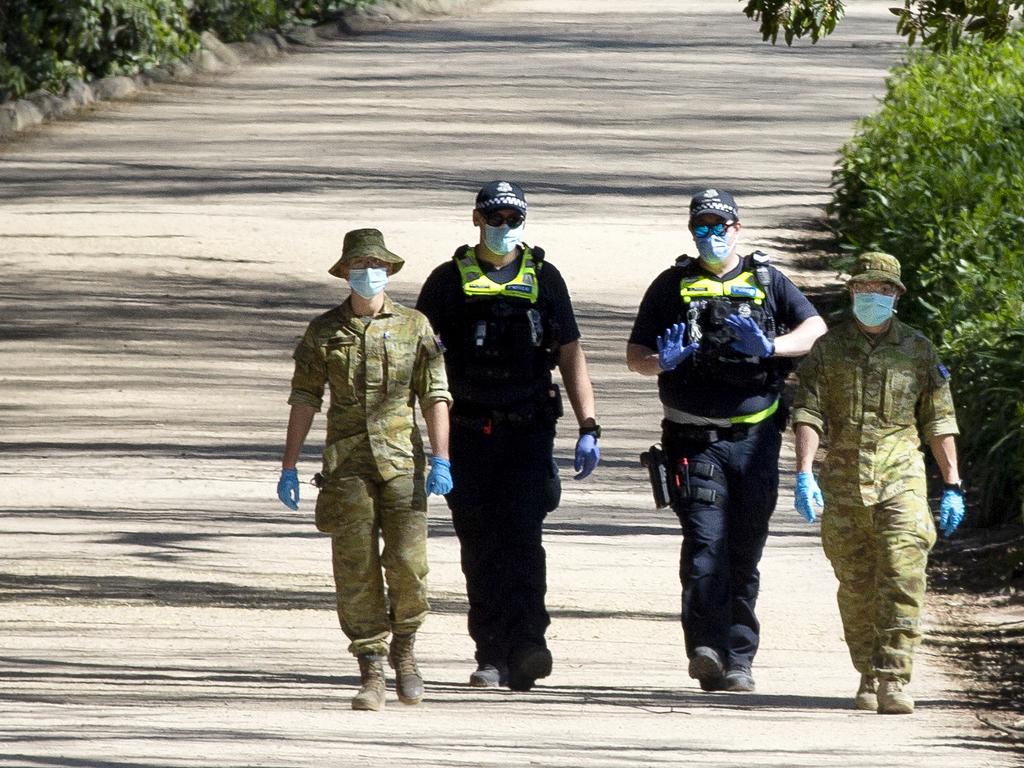 Police officers and army personnel patrol the Tan Track during stage 4 lockdowns. Picture: NCA NewsWire / David Geraghty