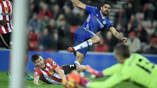 Sunderland's English goalkeeper Jordan Pickford (R) dives to save a shot from Diego Costa.