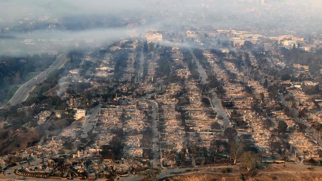 In this aerial view taken from a helicopter, homes burned from the Palisade fire smoulder near the Pacific Palisades neighbourhood. Picture: AFP