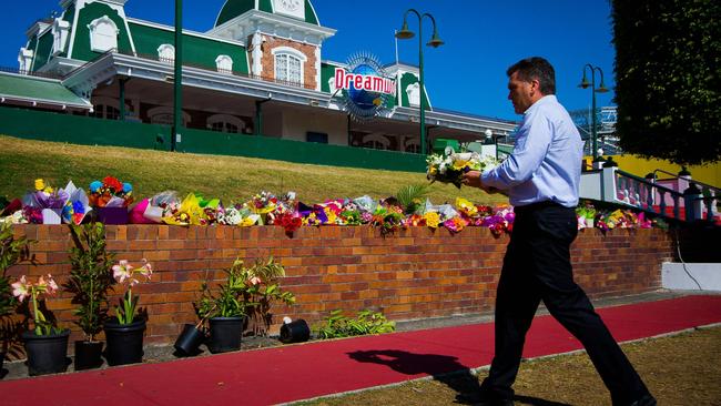 Dreamworld CEO Craig Davidson lays flowers at a makeshift floral tribute at the Dreamworld theme park on the Gold Coast. Picture: Patrick Hamilton