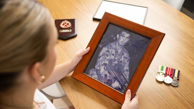 Mia Douglas with a photo of her father Kevin Douglas and his service medals. Photo: Joseph Byford Photography