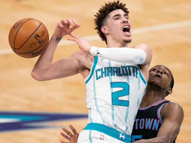 CHARLOTTE, NORTH CAROLINA - MARCH 15: LaMelo Ball #2 of the Charlotte Hornets loses the ball while guarded by De'Aaron Fox #5 of the Sacramento Kings during the fourth quarter game at Spectrum Center on March 15, 2021 in Charlotte, North Carolina. A foul was not called on the play. NOTE TO USER: User expressly acknowledges and agrees that, by downloading and or using this photograph, User is consenting to the terms and conditions of the Getty Images License Agreement.   Jacob Kupferman/Getty Images/AFP == FOR NEWSPAPERS, INTERNET, TELCOS & TELEVISION USE ONLY ==