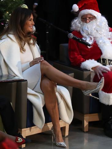 DECEMBER 07: It was an all-white Christmas outing for the First Lady when she draped a Max Mara coat over a sweater and pencil skirt to read to children at the Children’s National Medical Centre in Washington. Picture: Getty