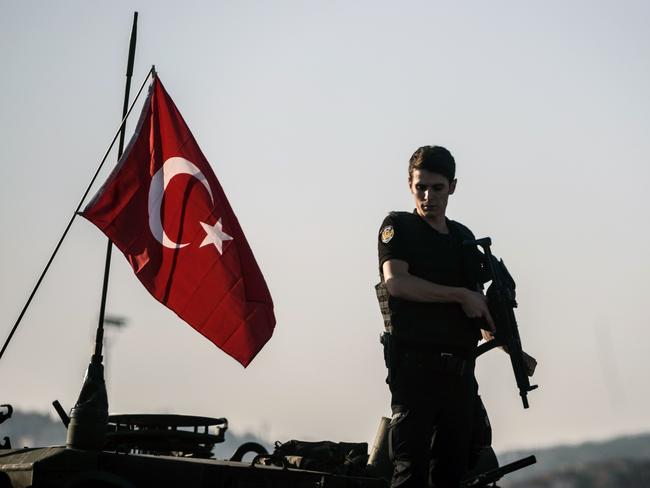 A Turkish anti-riot police officer stands guard on a tank after a military position on the Bosphorus Bridge during the attempted coup. Picture: Ozan Kose/AFP