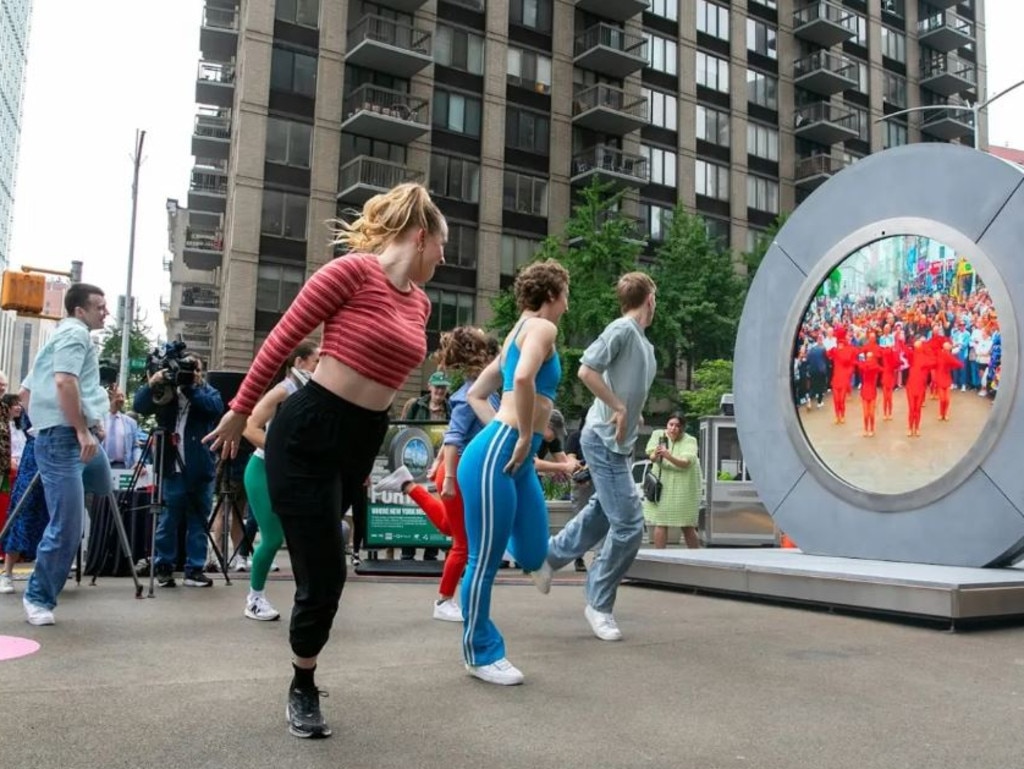 People dance in unison on both sides of the portal. Emily Tan / Simons Foundation