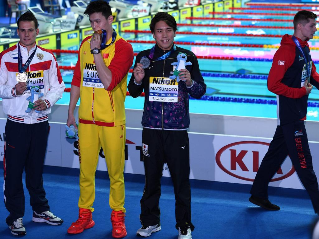 China's Sun Yang, silver medallist Japan's Katsuhiro Matsumoto (R) and tie bronze medallist Russia's Martin Malyutin (L) pose as tie bronze medallist Britain's Duncan Scott walks off.