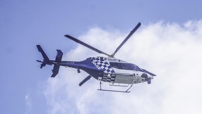 The PolAir 2 helicopter flies laps over Gilston in search of three alleged armed robbers on the loose. Photo: Luke Sorensen