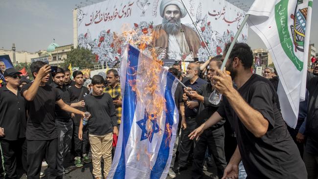 Iranians burn a representation of the Israeli flag during the funeral ceremony of Hamas leader Ismail Haniyeh in Tehran, Iran. Picture: Majid Saeedi/Getty Images