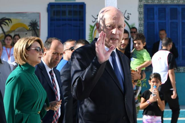 Tunisia's President Kais Saied waves outside a polling station in Tunis after casting his vote in the affluent Ennasr neighbourhood