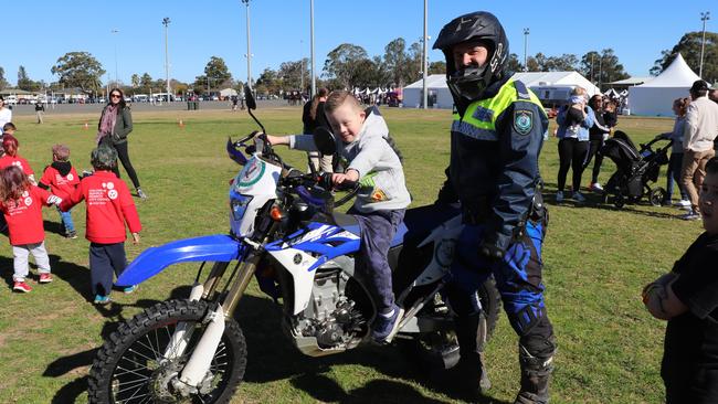 Cobi Graham, 7, of South Penrith sits on top of officer Andrew Hayward's police trail bike at NAIDOC celebrations in Jamison Park, Penrith on Friday. Picture: Danielle Jarvis