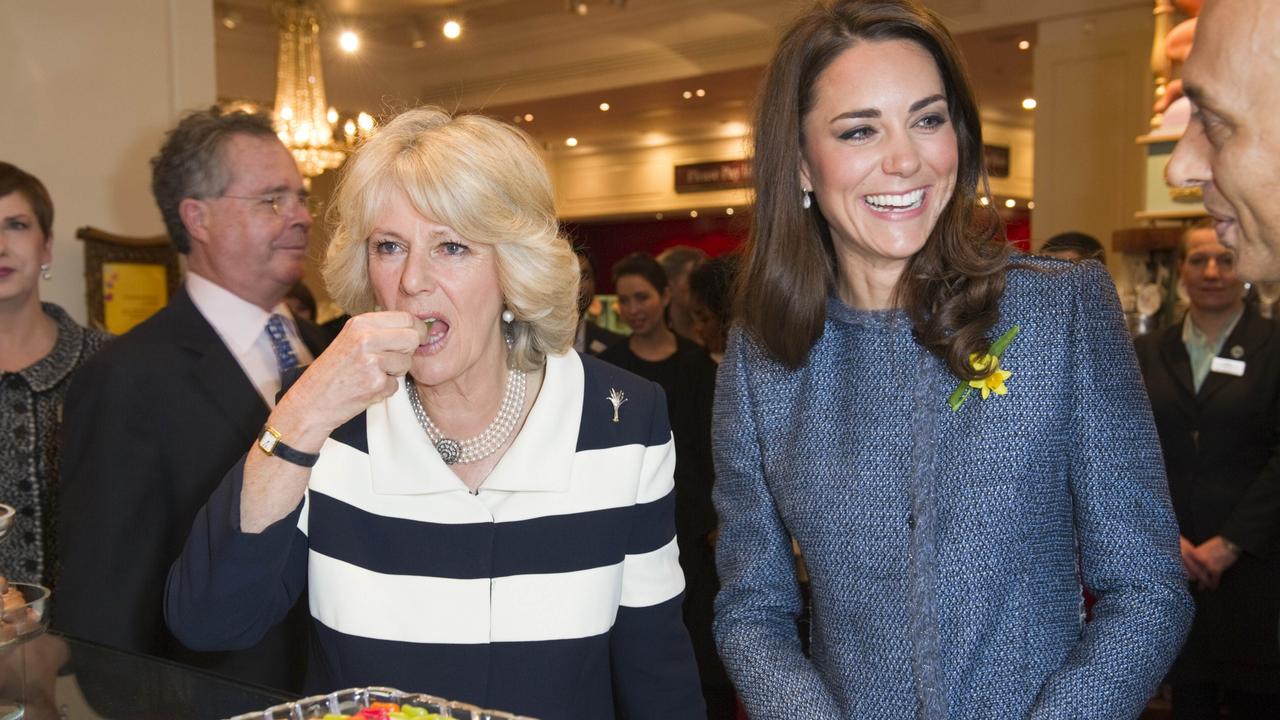 Camilla tastes a sweet as Kate smiles during royal duties in 2012. Picture: AFP