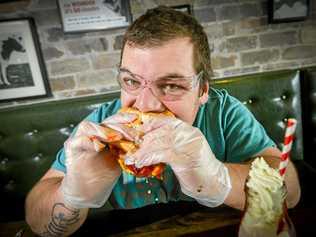 HEATED SITUATION: Brenton Rouvray bravely devoured the Double Decker Death Wish burger at Gladstone's Stockland shopping centre on July 11, 2018. Picture: Matt Taylor GLA110718BURG
