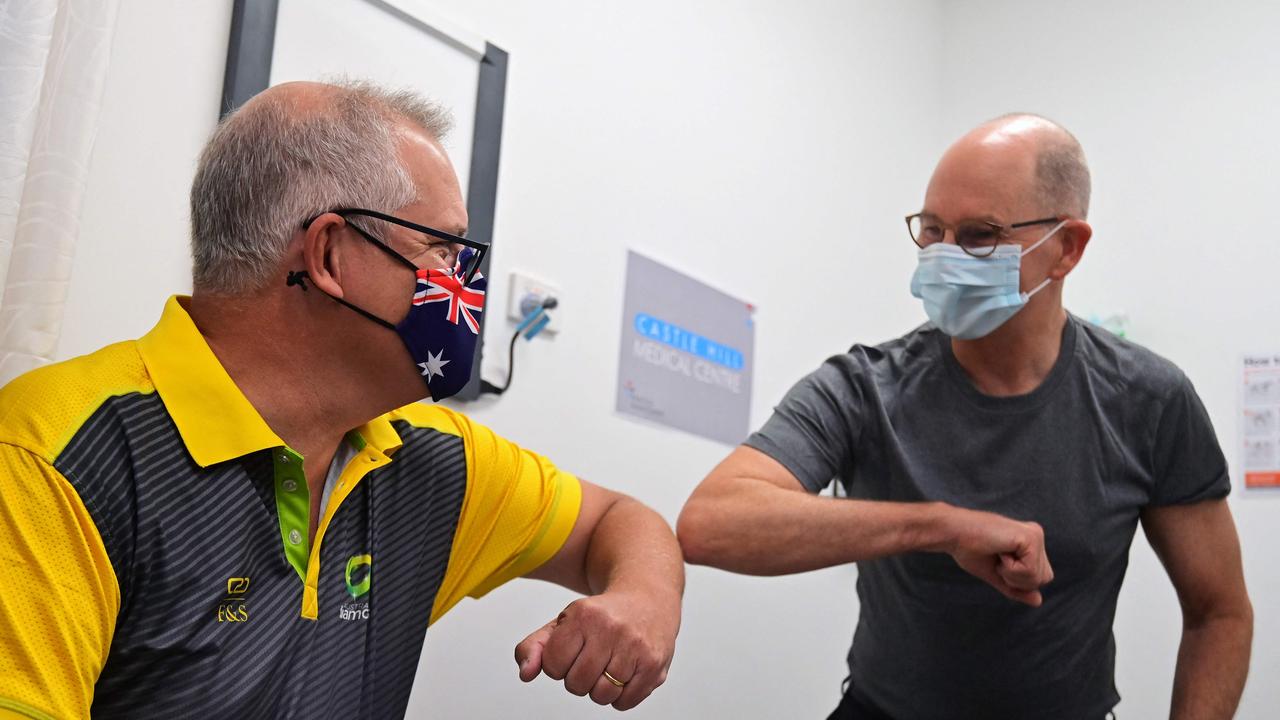 Scott Morrison bumps elbows with Australian Government Chief Medical Officer Paul Kelly after they both received a dose of the COVID-19 vaccine on February 21. Picture: Steven Saphore/AFP