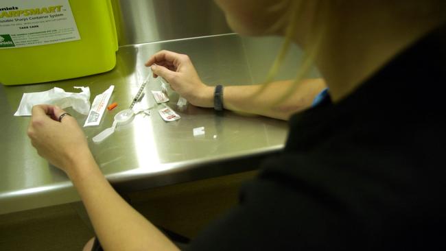 A Kings Cross injecting centre staff member stages a simulation of a drug user using a syringe to shoot up heroin.