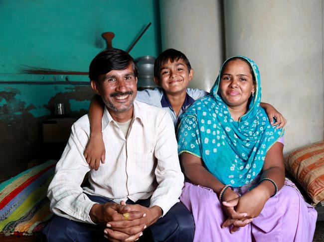 Cheerful Indian Family sitting on the cot smiling portrait with studio lights.